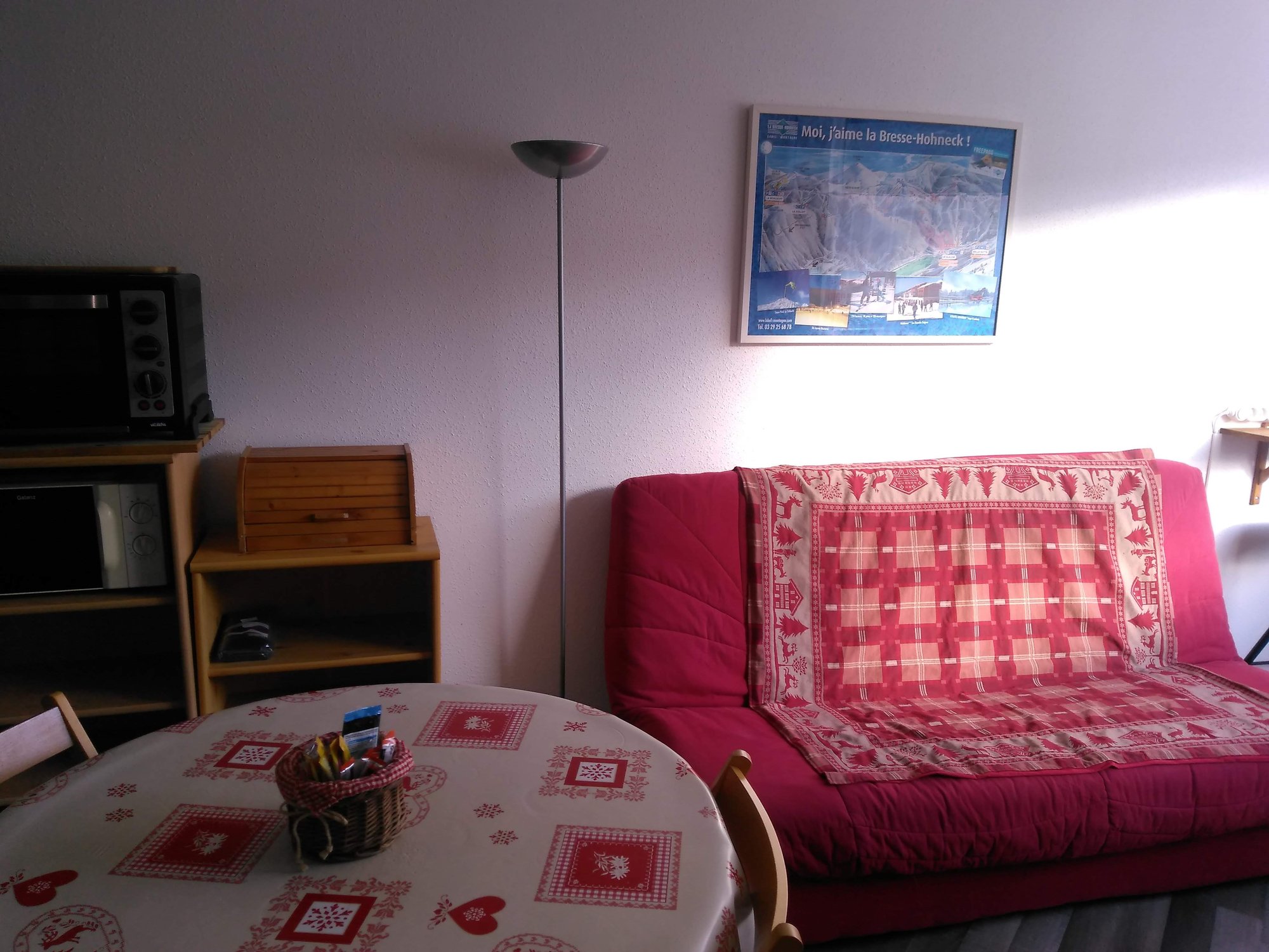 L'espace de vie du studio avec table et clic-clac